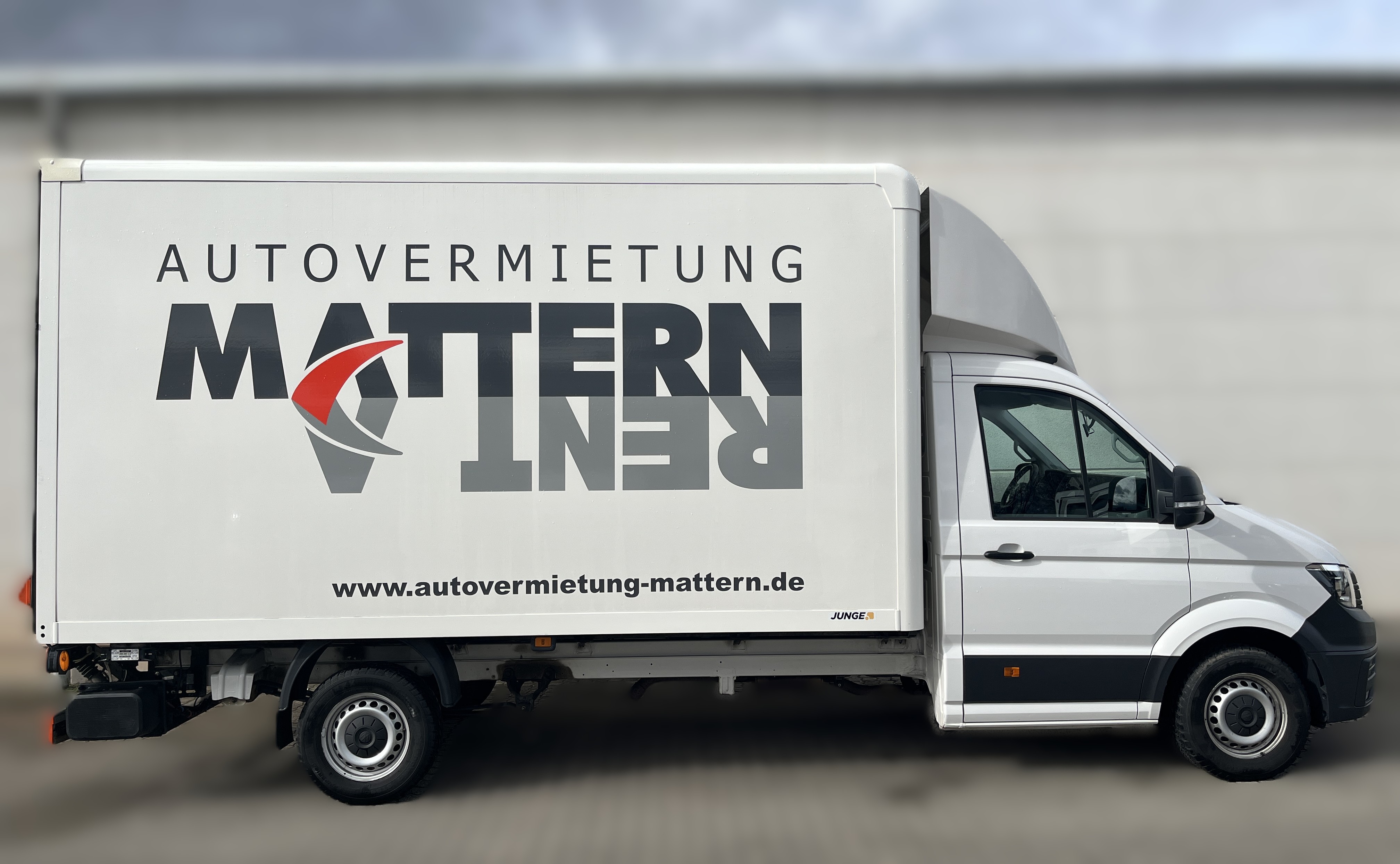 Weisser Lieferwagen mit grossem schwarzen und roten MATTERN RENT Logo an der Seite