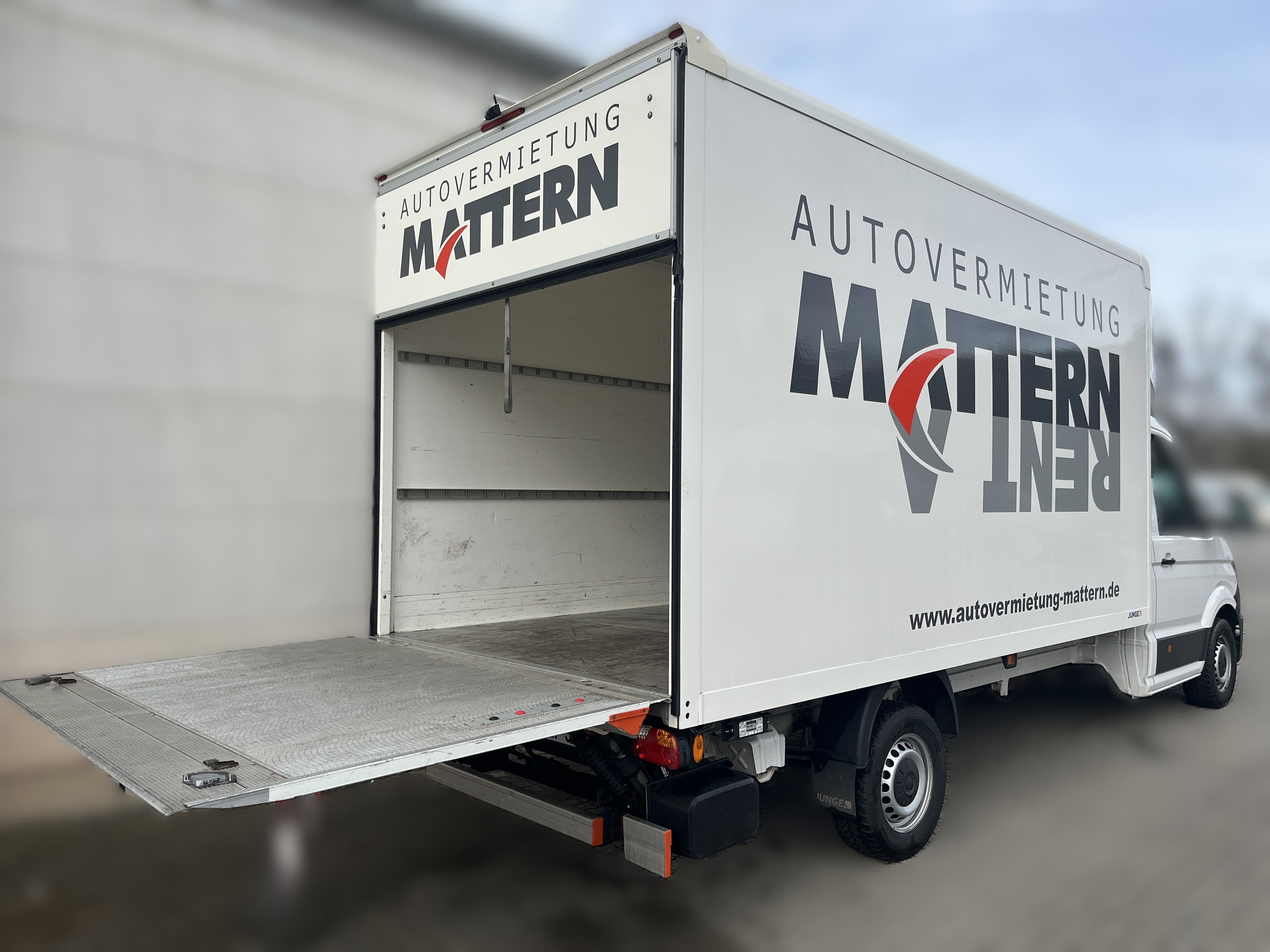 Ein weißer Miettransporter mit geöffneter Ladebordwand und MATTERN Logo auf dem Aufbau