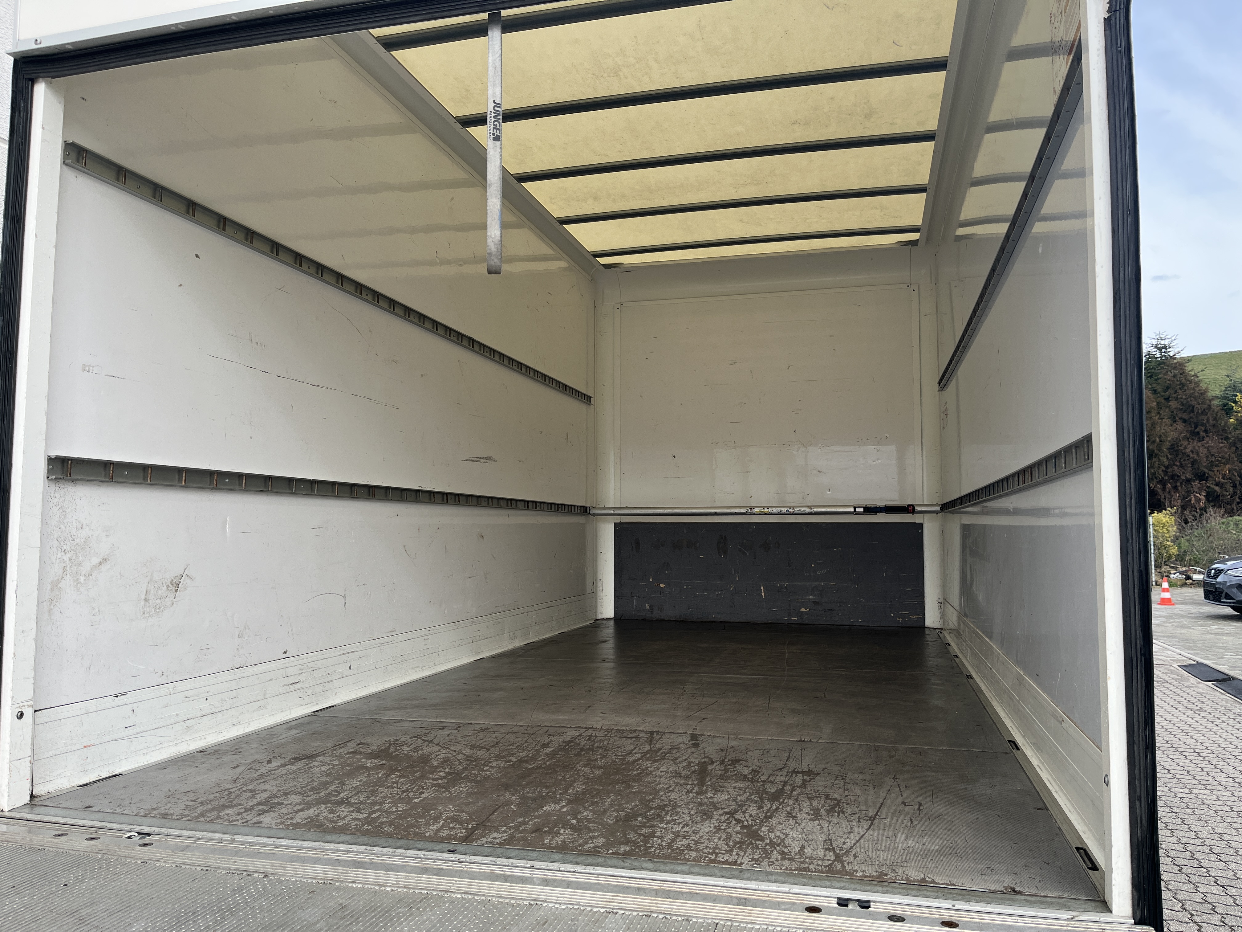 Leerer weißer LKW mit hellem Innenraum und offenem Heck auf einem Parkplatz