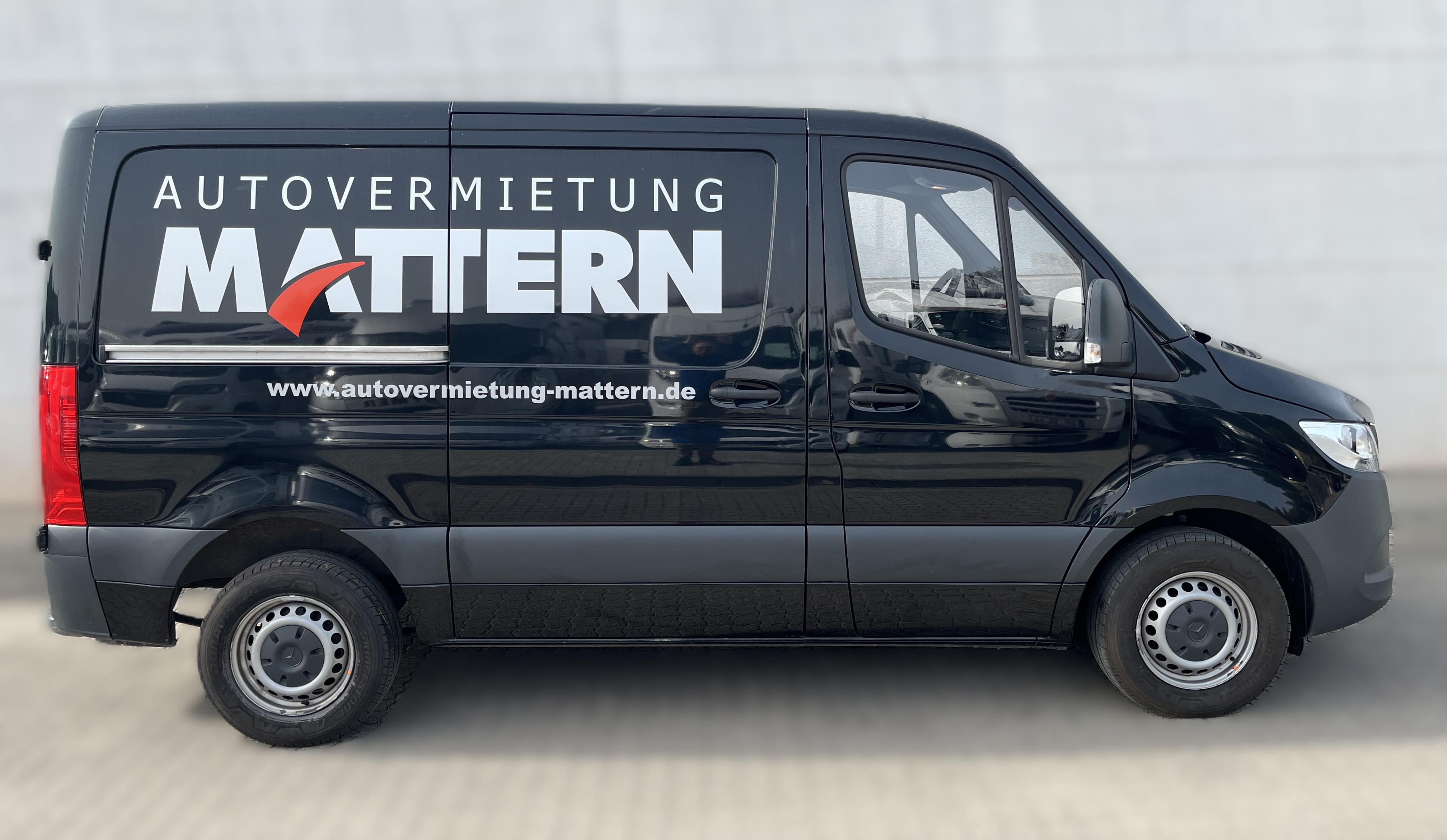 Ein schwarzer Transporter mit auffälligem MATTERN Logo und weißer Beschriftung