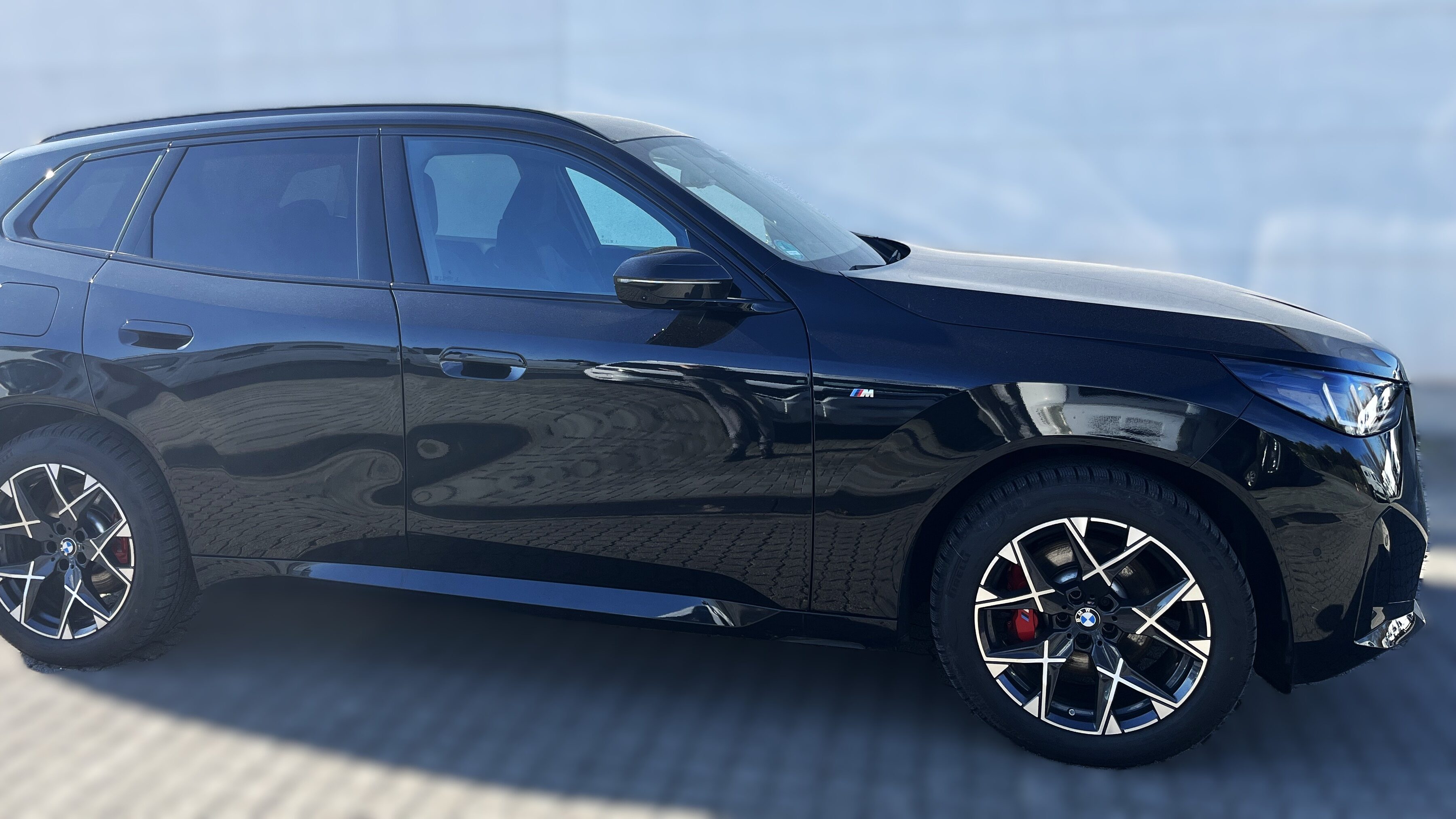 Schwarzer SUV mit sportlichem Design und glänzenden Felgen auf grauem Boden