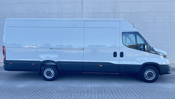 Großer weißer Lieferwagen mit glatten Seiten und dunklen Stoßfängern auf grauem Pflaster